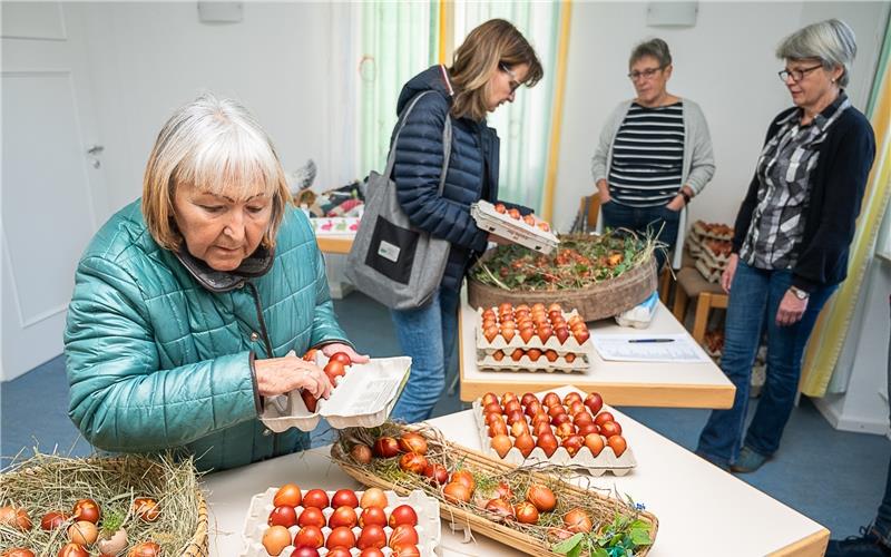 Das Ostereierteam der Kirchengemeinde Tailfingen bietet gekochte, gefärbte und gestaltete Ostereier zum Verkauf an – und Kundin Monika Neumann hat die Qual der Wahl.GB-Foto: Schmidt